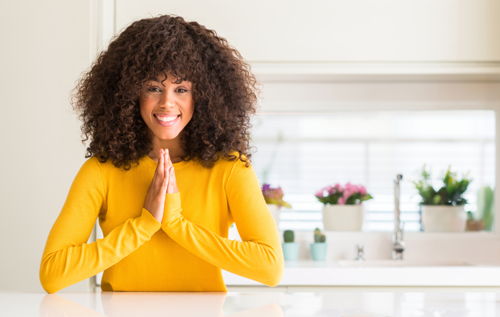 A woman in prayer, hands lifted in faith